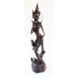 A 33" Siamese carved hardwood figure of Saraswati with spired crown and bird to leg, stood atop