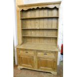 A 4' 9" late Victorian pine dresser with three shelf open plate rack, over a base with bowl slide,