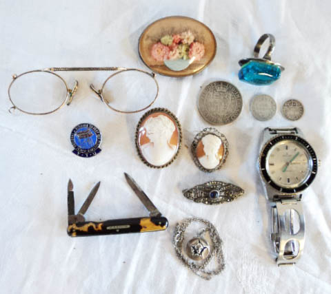 A box containing collectable items including pince-nez, cameos brooches, Victorian silver coins,