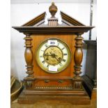 A stained walnut cased German mantel clock of architectural design, with embossed poppy decoration