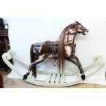 A 3' 4" high antique stocky dapple grey rocking horse with long mane and tail, leather tack and