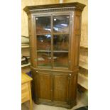 A 3' 10" 19th Century oak two part corner cabinet with moulded cornice, panelled canted sides and