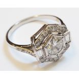 An 18ct. white gold Art Deco style ring set with central diamond, flanking baguettes and diamond