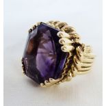 An ornate yellow metal dress ring with claw set large amethyst, rope twist border and multi-band