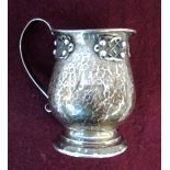 An Arts and Crafts baluster form child's cup with hammered finish and applied decoration - London