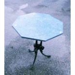 A 24" octagonal green marble topped table, set on a cast iron base with pillared column and