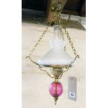 A Murano cranberry glass and brass hanging oil lamp with chimney and milk glass shade