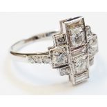 An 18ct. white gold Art Deco style diamond encrusted stepped panel ring, set with three central