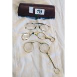A case containing two pairs of gilt metal framed lorgnettes and a pair of pince nez