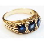 An 18ct. gold ring, set with three sapphires interspersed with small diamonds