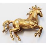 An 18ct. gold horse pattern brooch with small ruby set eyes and diamond set highlights - B. R. Ltd.