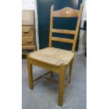 A set of six golden oak framed ladder back dining chairs with rush seats and square supports