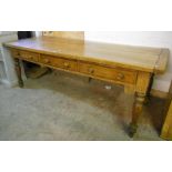 A 7' 1" golden oak thick plank top farmhouse kitchen table with three frieze drawers, set on
