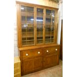 A 5' 6" Victorian stained pine two part dresser with four shelf glazed top over a base with two deep