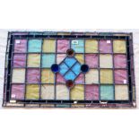 A multicoloured stained glass window panel of geometric design - 32 1/2" x 19"