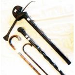 A Nigerian hardwood and iron adze head topped stick, bamboo walking cane with white metal cap and