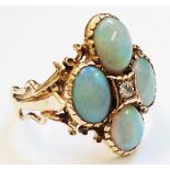 A 9ct. gold ring set with central small diamond and four cabochon opals, the shank with pierced