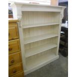 A 36 1/2" painted pine four shelf open bookcase with moulded top and acanthus scroll capitals, set