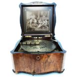 A walnut cased Polyphon with inlaid decoration to lid and internal monochrome print depicting a