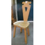 A bleached wood spinning chair with heart pierced back and moulded solid seat