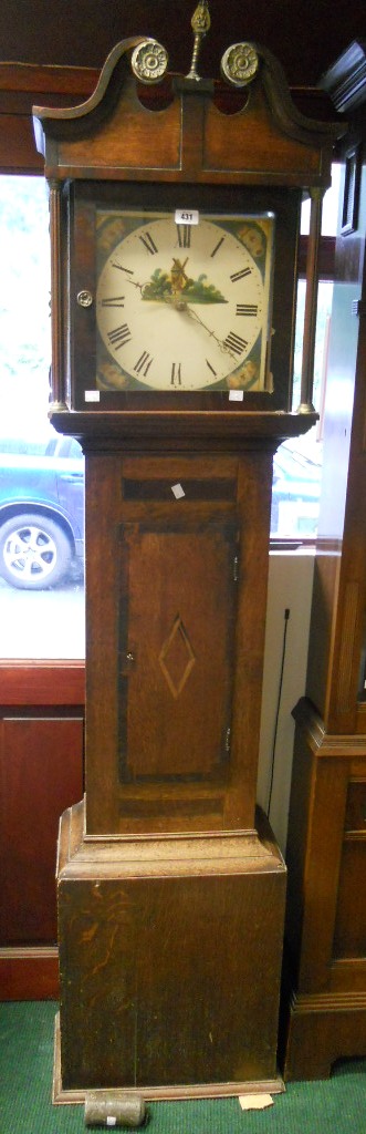 An antique oak longcase clock with brass decorated swan neck pediment, 12" square painted dial,