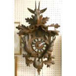 A carved stained wood "Black Forest" cuckoo clock, with twin pine cone weight driven movement