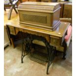 A Singer treadle sewing machine, No. 11417763, with tools, booklets and oak cover