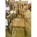 A Windsor stick back elbow chair with solid elm seat and ring turned supports