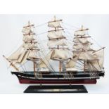 A 28 1/2" wooden model of the Cutty Sark fixed on a wooden base