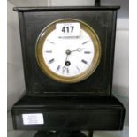 A late Victorian black slate cased mantel timepiece with eight day movement