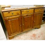 A 4' 4" Ducal stained pine sideboard with moulded top, three drawers and three panelled cupboard