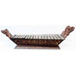 A 4' 11" antique Indonesian teak and ironwood gambang kayu (xylophone), with ornately carved wings