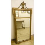 A 25 1/2" Regency style gilt framed pier mirror with vase and swag pediment, floral boss and