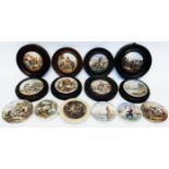 A collection of framed and unframed antique pot lids with scenic decoration, including "War", "I