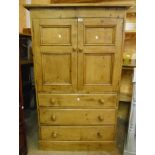 A 3' 1 1/2" waxed pine cupboard with two panelled doors enclosing three shelves, over three long