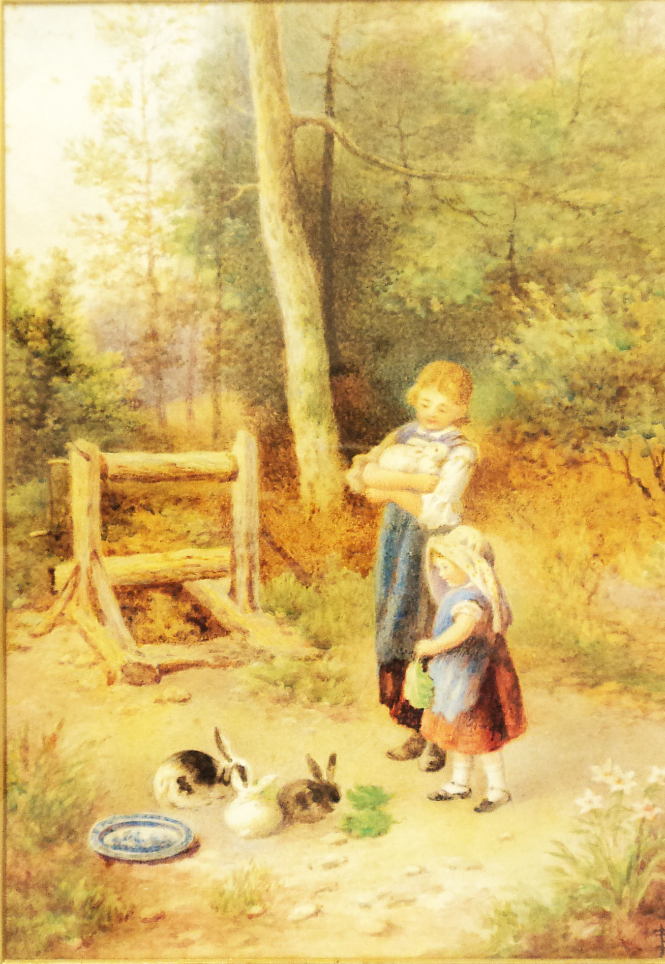In the manner of Myles Birkett Foster: a gilt framed watercolour depicting two girls feeding rabbits