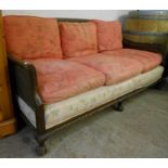 A 1920's oak framed two seater settee with double skinned bergere back and sides scroll arms and