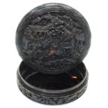 A 3½" 19th Century Chinese tortoiseshell circular snuff box, the lid with heavily carved scene