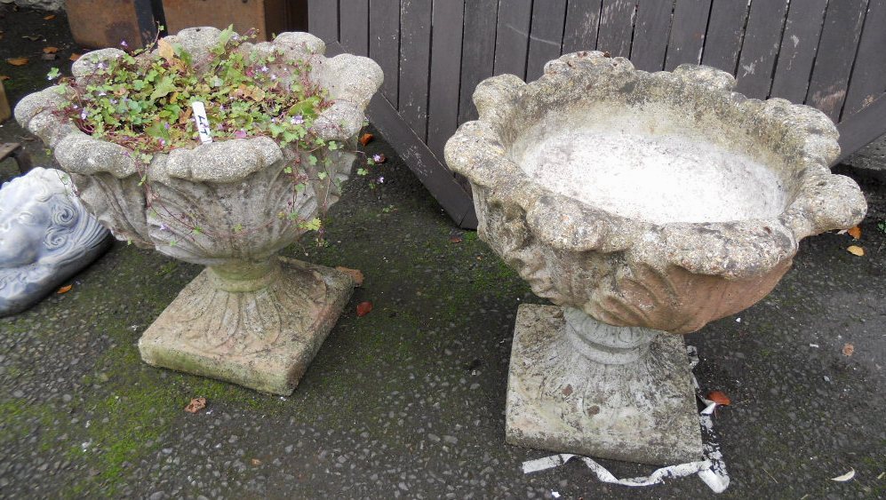 A pair of ornate concrete planters with allover acanthus leaf decoration