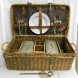 An early 20th Century wicker picnic basket with fitted interior and contents