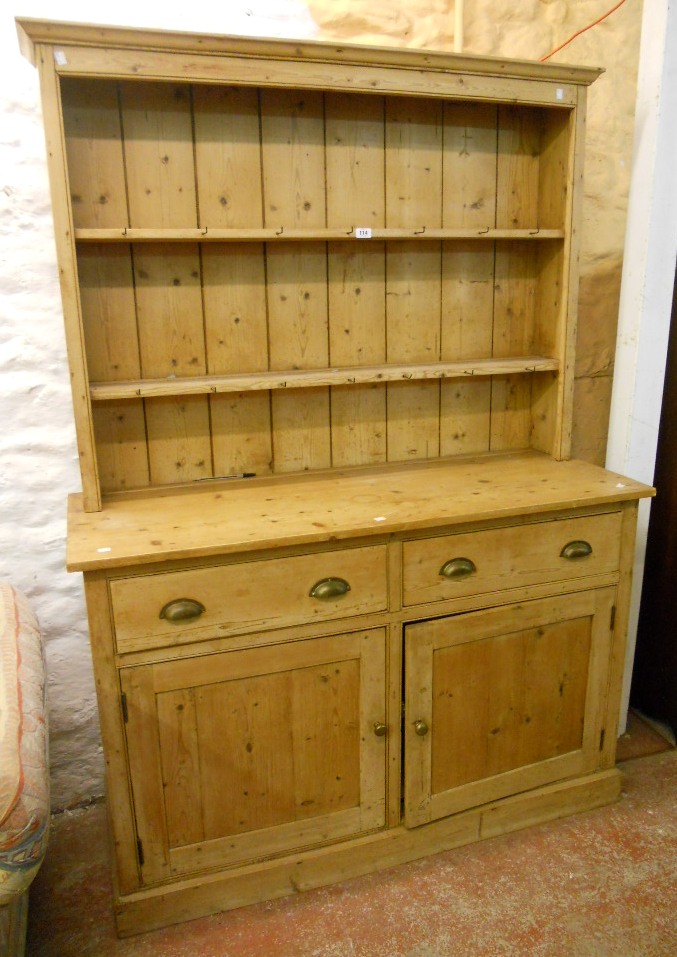 A 4' 6" Victorian stripped pine dresser with two shelf open plate rack, over a base with two short