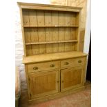 A 4' 6" Victorian stripped pine dresser with two shelf open plate rack, over a base with two short