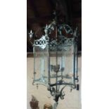 A large French patinated metal framed hall lantern of faceted design with scroll decoration and