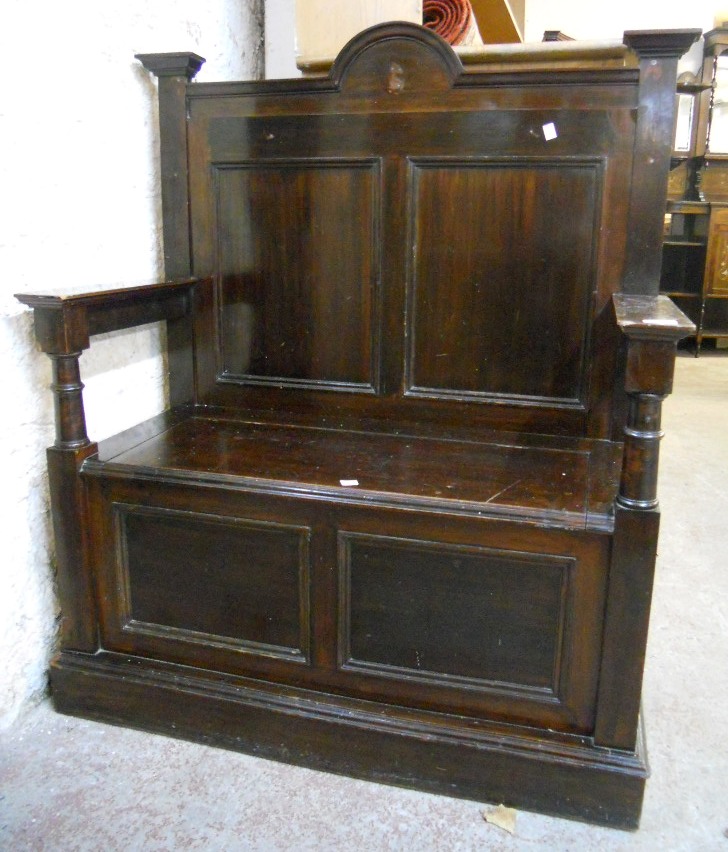 A 3' 1½" early 20th Century stained wood settle with shaped panelled back, flanking turned
