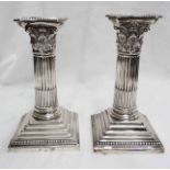 A pair of 6" silver Corinthian column candlesticks with detachable nozzles and loaded step plinth