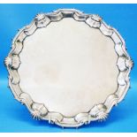 A 10" diameter George II silver salver by William Peaston with cast shell scroll rim set on stylised