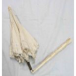 A 19th Century cream silk parasol with carved ivory handle and finial