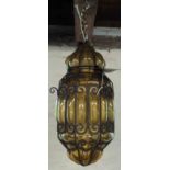 An Arts and Crafts period iron framed and amber bubble glass pendant light with scroll decoration