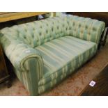 A 5' 8" 1930's Chesterfield settee with green and cream striped button back upholstery