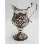 An antique silver pedestal jug with embossed floral decoration and engraved AM, 1771, MFC -